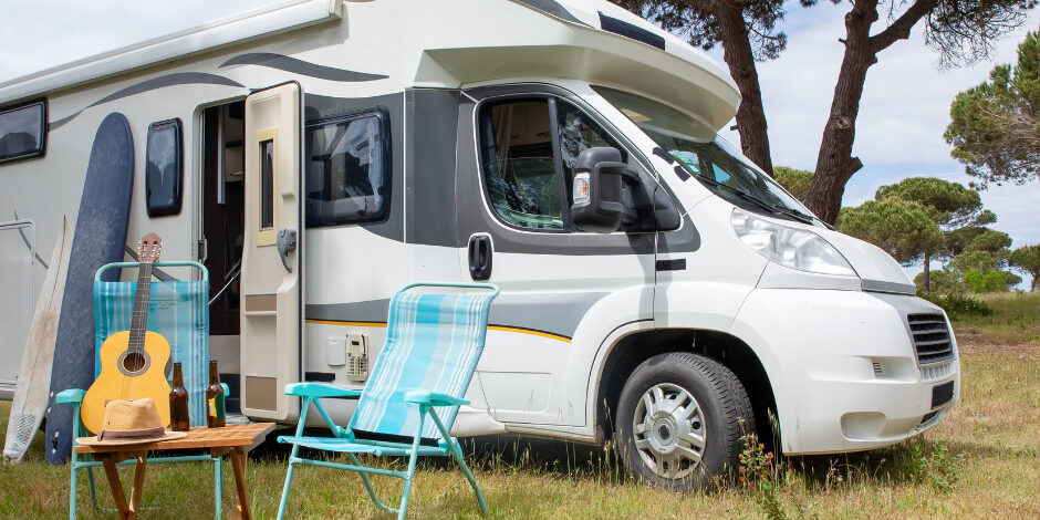 Camper with 2 lawn chairs guitar hat and 2 drinks
